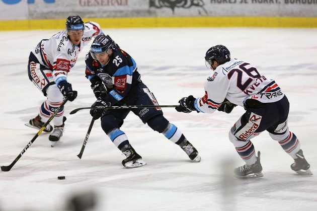 Liberecký hokejista Radan Lenc z Liberce se snaží prosadit mezi dvojicí hráčů Vítkovic během utkání 38. kola extraligy
