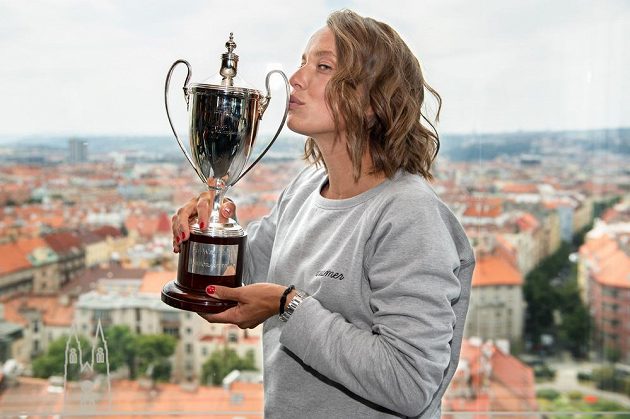 Polibek šampionky. Tenistka Barbora Strýcová s trofejí za vítězství ve čtyřhře ve Wimbledonu.