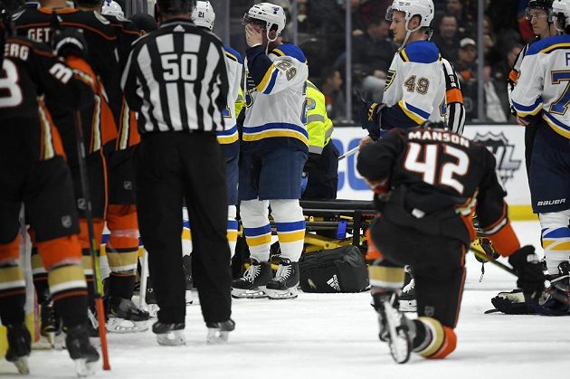 Obránce St. Louis Blues Vince Dunn (vlevo) a bek Anaheimu Josh Manson poté, co Jay Bouwmeester v první třetině zkolaboval na střídačce.