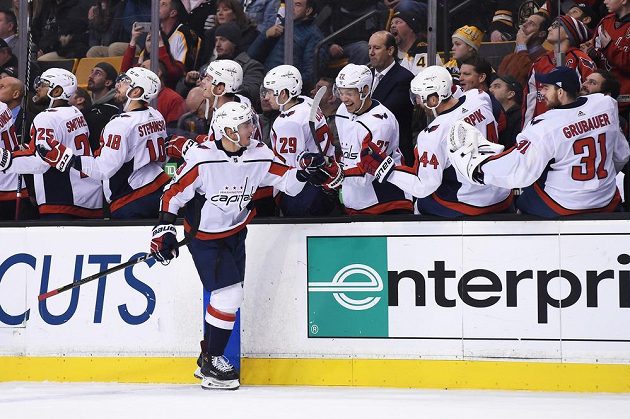 Český útočník Jakub Vrána přijímá gratulace od hokejistů Washingtonu poté, co se trefil v NHL na ledě Bostonu.