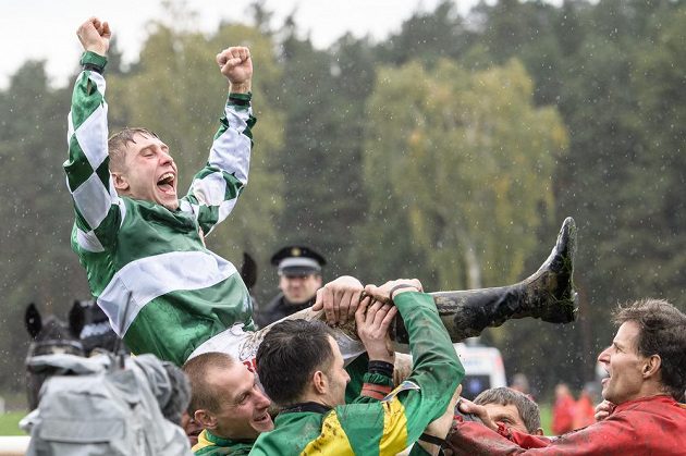 Vítězný žokej Jan Kratochvíl nad hlavami svých kolegů po triumfu ve Velké pardubické.