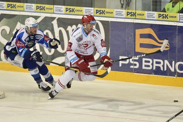 Martin Dočekal z Brna a Tomáš Linhart z Třince spěchají za pukem v utkání 27. kola hokejové extraligy.