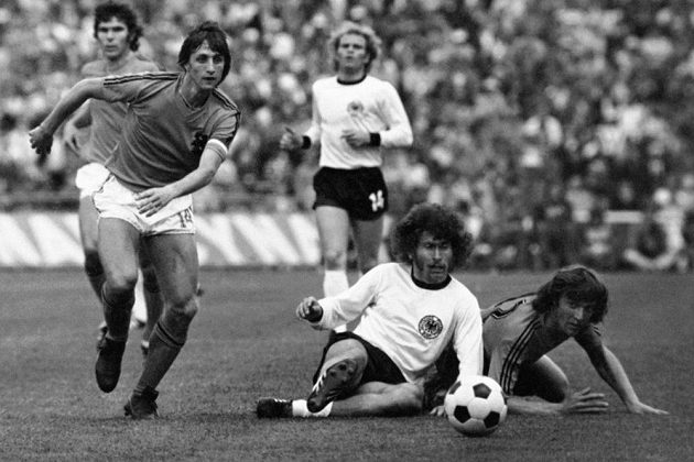 Nizozemec Johan Cruyff (vlevo) uniká podél sedícího německého fotbalisty Paula Breitnera ve finále MS na Olympijském stadiónu v Mnichově.