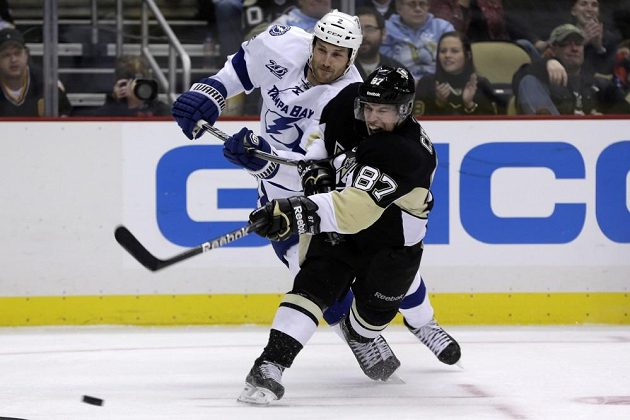 Sidney Crosby z Pittsburghu (v černém dresu) se dostal ke střele přes bránícího zadáka Tampy Bay Erica Brewera.