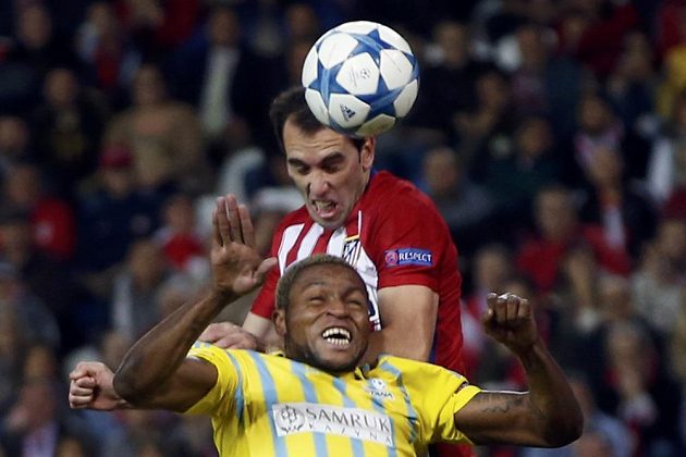 Diego Godín (nahoře) z Atlétika Madrid v souboji s Juniorem Kabanangou z Astany.
