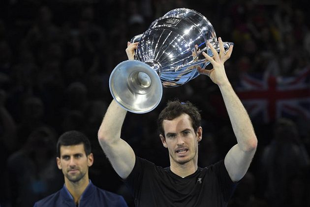 Andy Murray z Velké Británie s trofejí pro vítěze Turnaje mistrů. V pozadí poražený finalista Novak Djokovič ze Srbska.