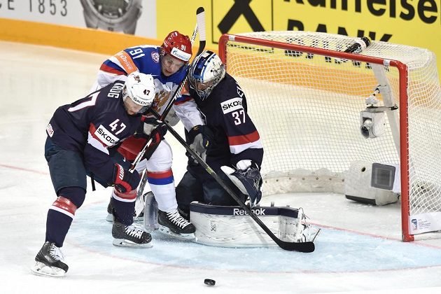 Ruský útočník Vladimir Tarasenko, obránce Torey Krug z USA a brankář Connor Helebuyck během utkání semifinále.
