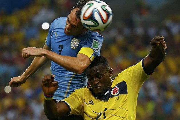 Uruguayský obránce Diego Godín (vlevo) v hlavičkovém souboji s Jacksonem Martínezem z Kolumbie.