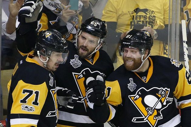Ron Hainsey (uprostřed) z Pittsburghu , se raduje z gólu proti Nashvillu s Jevgenijem Malkinem (vlevo) a Philem Kesselem.