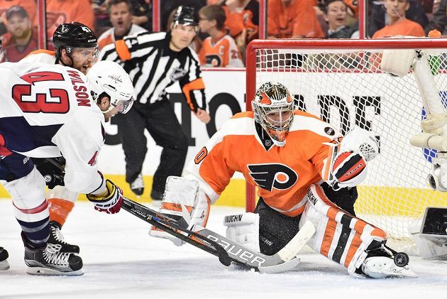 Michal Neuvirth v brance Philadelphie kryje střelu Toma Wilsona z Washingtonu.