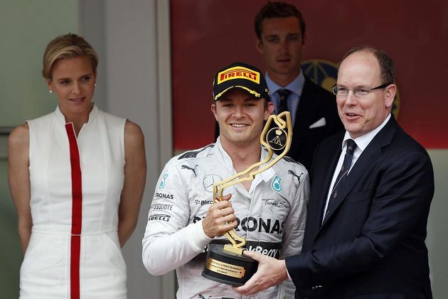 Nico Rosberg (uprostřed) dostává trofej pro vítěze GP Monaka od knížete Alberta II, jehož partenrka Charlene přihlíží v pozadí.