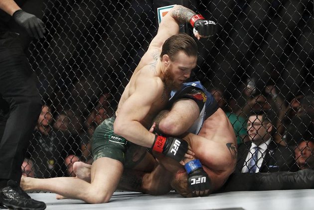Conor McGregor (vlevo) trefuje svého soupeře Donalda Cerroneho v zápase organizace UFC.