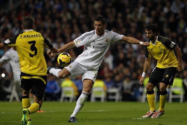 Cristiano Ronaldo (uprostřed) střílí na branku Sevilly za asistence Fernanda Navarra (vlevo) a Nicolase Pareji.