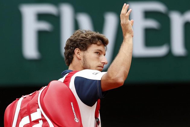 Španěl Pablo Carreňo Busta mává fanouškům poté, co musel vzdát duel s Rafaelem Nadalem.