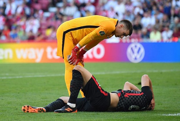 Croatian goalkeeper Dominik Livakovič bends over the injured teammate Josk Gvardiol. 