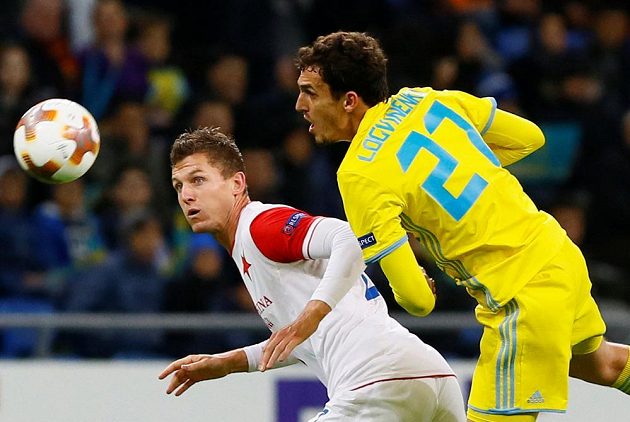 Útočník Slavie Tomáš Necid v souboji s Jurijem Logviněnkem z Astany v utkání Evropské ligy.