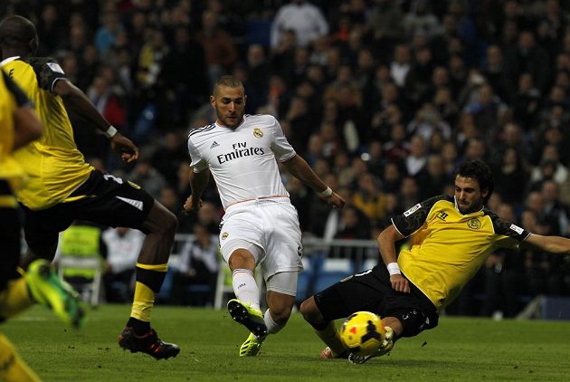 Karim Benzema (uprostřed) dává gól Realu, Stéphane M'Bia (vlevo) ani Nicolas Pareja (vpravo)ze Sevilly už zakročit nestačili.