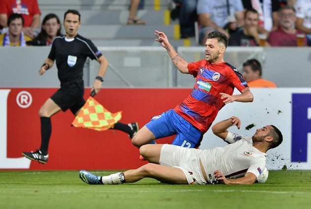 Michal Ďuriš z Viktorie Plzeň a Kostas Manolas z AS Řím (ležící) v tvrdém souboji o balón.