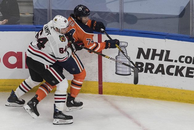 Ethan Bear (74) z Edmontonu Oilers čelí ataku Davida Kampfa z Chicaga Blackhawks.