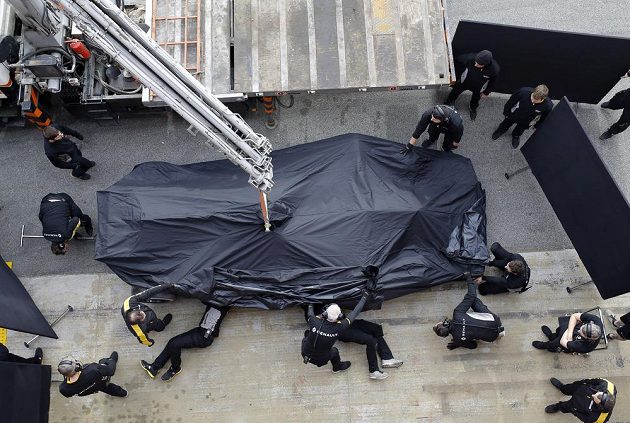 Mechanici Renaultu vykládají vůz z odtahového vozu po nehodě Jolyona Palmera.