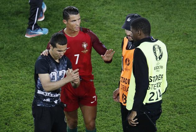 Cristiano Ronaldo domlouvá pořadatelům. S fanouškem, který vnikl na hrací plochu, se ochotně vyfotil.