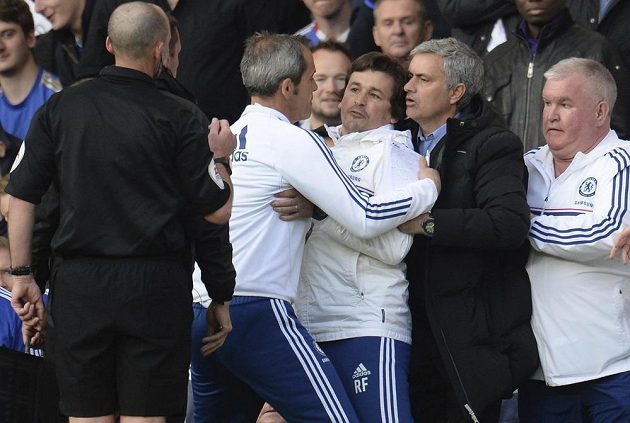 Kouč Chelsea José Mourinho (druhý zprava) uklidňuje svého asistenta Fariu (uprostřed), který u rozhodčího Deana (vlevo) protestuje proti nařízení pokutového kopu ve prospěch Sunderlandu.