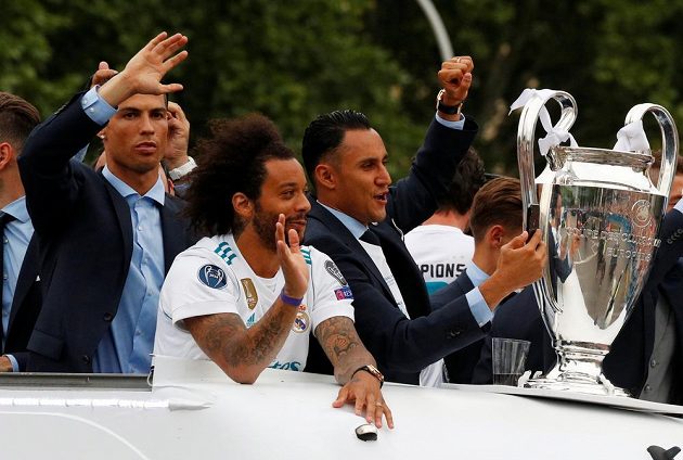 Fotbalisté Realu Madrid a jejich oslava s fanoušky po triumfu v Lize mistrů. Většina hráčů zářila nadšením, Cristiano Ronaldo však vyloudil úsměv na tváři jen občas.