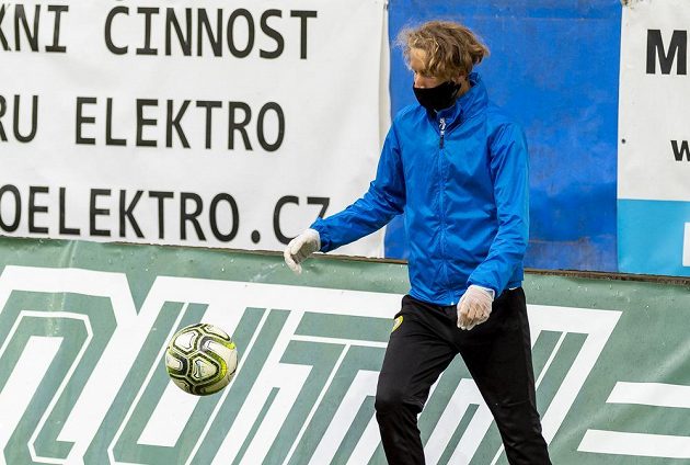 Podavač míčů s rouškou a rukavicemi na ochranu proti koronaviru v ligovém utkání Teplice - Liberec.