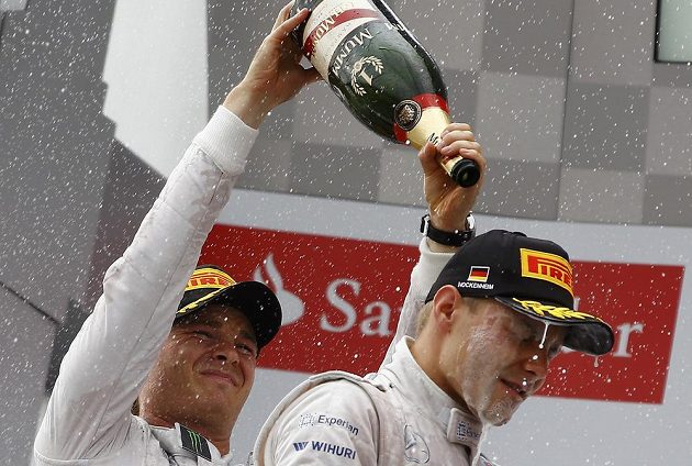 Nico Rosberg (vlevo) a druhý Fin Valtteri Bottas při oslavách na stupních vítězů.