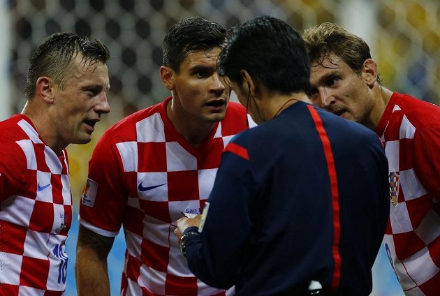 Fotbalisté Chorvatska Ivica Olič (vlevo), Dejan Lovren (uprostřed) a Nikica Jelavič protestují proti nařízené penaltě. Zády stojí japonský rozhodčí Jujči Nišimura.