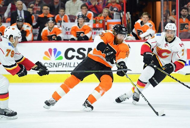 Útočník Philadelphie Jakub Voráček prochází mezi dvojicí hráčů Calgary Michealem Ferlandem (vlevo) a T.J. Brodiem.