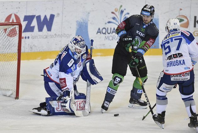 Brněnský brankář Karel Vejmelka sleduje stejně jako Tomáš Knotek z Mladé Boleslavi puk během extraligového utkání. Zabránit v zakončení se snaží Jan Hruška z Brna.