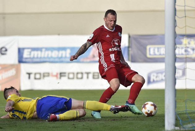Olomoucký útočník Jakub Řezníček (vpravo) střílí gól. Vlevo je Ondřej Bačo ze Zlína.