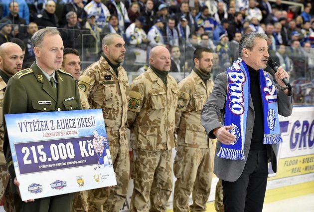 Před zápasem Brno - Třinec předal domácí klub zástupcům Vojenského fondu solidarity výtěžek z aukce dresů z Hokejových her 2016. Na snímku vlevo je předseda fondu a zástupce náčelníka generálního štábu Jaroslav Kocián s věnovaným šekem na 215 000 korun, vpravo ministr obrany Martin Stropnický.