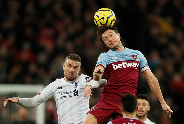 Liverpoolský fotbalista Jordan Henderson v hlavičkovém souboji s Markem Noblem z West Hamu United.