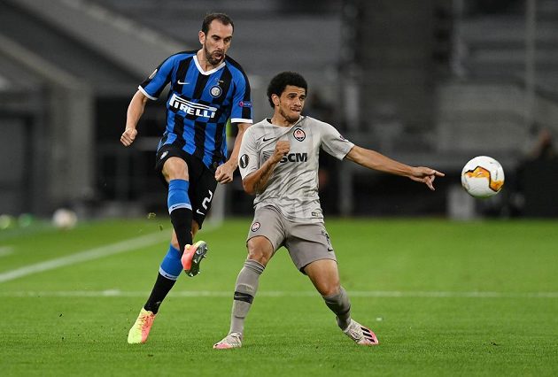 Obránce milánského Interu Diego Godín (vlevo) odkopává míč do bezpečí před Taisonem ze Šachtaru Doněck.