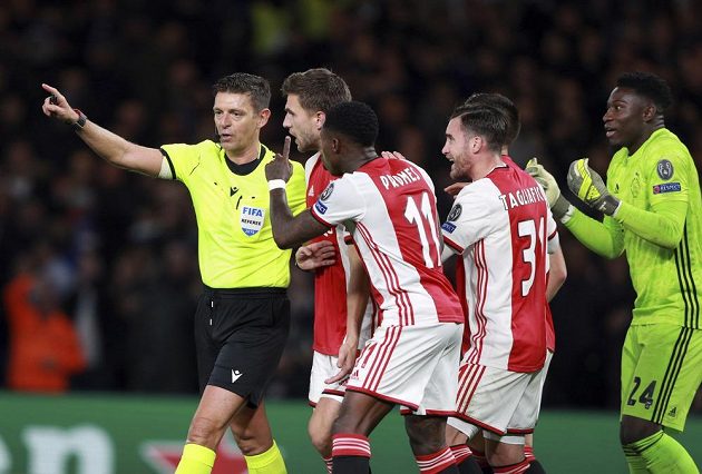 Rozhodčí Gianluca Rocchi vysvětluje hráčům Ajaxu udělení červených karet i odpískanou penaltu během utkání Ligy mistrů.
