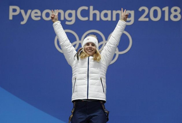 Vítězné gesto zlaté medailistky Ester Ledecké při slavnostním ceremoniálu. Ledecká vyhrála senzačně super-G.