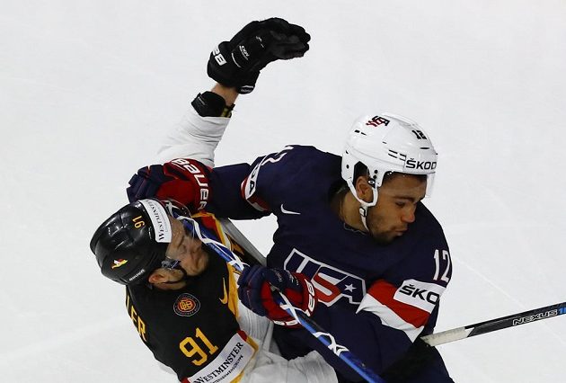 Ostrý souboj Jordana Greenwaye z USA a Moritze Müllera z Německa během utkání hokejového mistrovství světa.