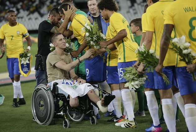 Bývalý brankář klubu Chapecoense Follmann se spolu s Alanem Ruschelem zdraví s fotbalisty Brazílie před zápasem, kde byla uctěna památka tragicky zesnulých fotbalistů Chapecoense