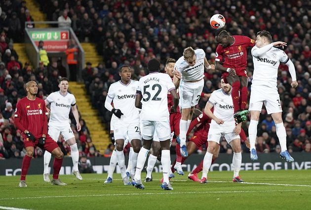 Liverpoolský útočník Sadio Mané ve vzdušném souboji s hráči West Hamu v utkání Premier League.