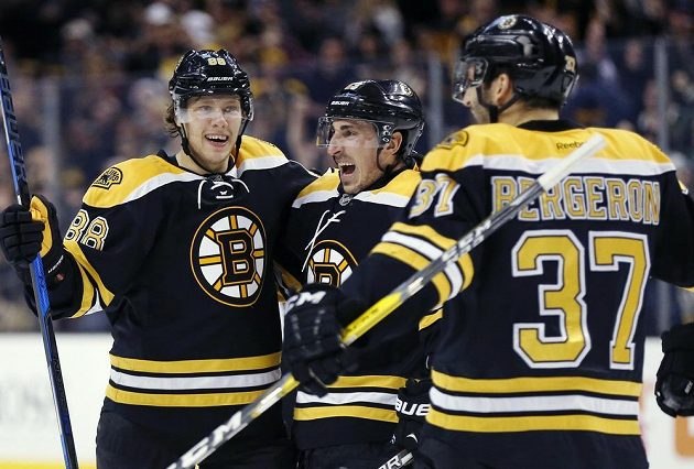 David Pastrňák (88) z Bostonu se raduje po svém druhém gólu proti Coloradu s Bradem Marchandem (uprostřed) a Patricem Bergeronem (37).