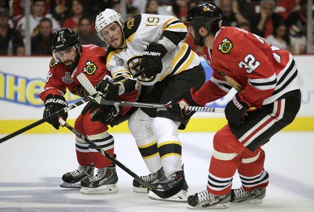 Útočník Bruins Tyler Seguin (uprostřed) v sevření chicagských zadáků Nicka Leddyho (vlevo) a Michala Rozsívala.