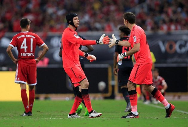 Tak zlom vaz! Petr Čech (vlevo) předává žezlo argentinskému kolegovi Damianu Martínezovi.