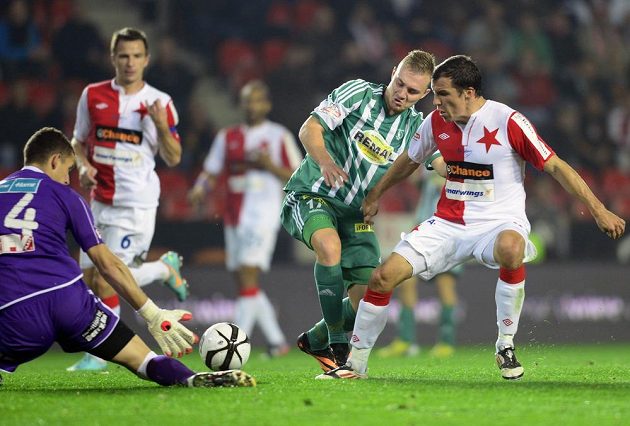 Brankář Slavie Matej Rakovan (vlevo) zasahuje před Jakubem Horou z Bohemians 1905 (uprostřed). Vpravo je Martin Dostál ze Slavie.
