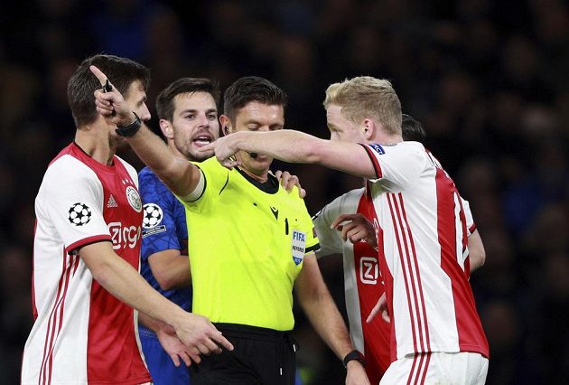 Rozhodčí Gianluca Rocchi v obležení hráčů Ajaxu během utkání Ligy mistrů na hřišti Chelsea.