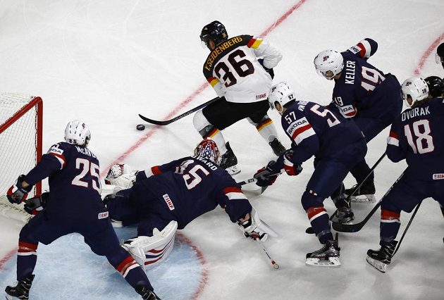 Německý hokejista Frederik Tiffels útočí. Před brankou USA čelí přesile soupeřů v čele s gólmanem Jimmy Howardem.