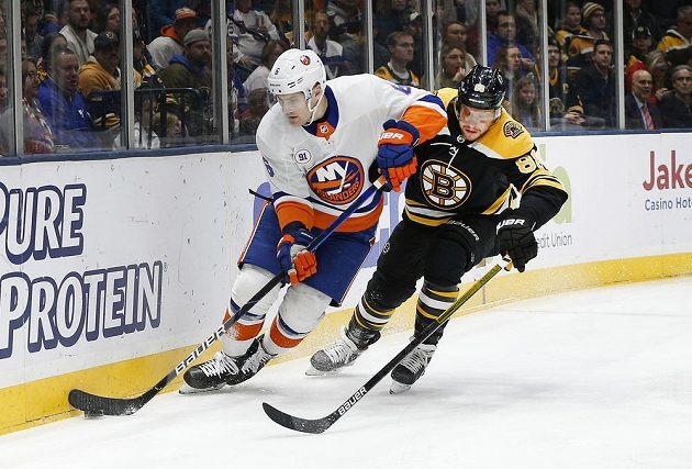 Obránce New Yorku Islanders Ryan Pulock (6) vedle Davida Pastrňáka (88) z Bostonu.