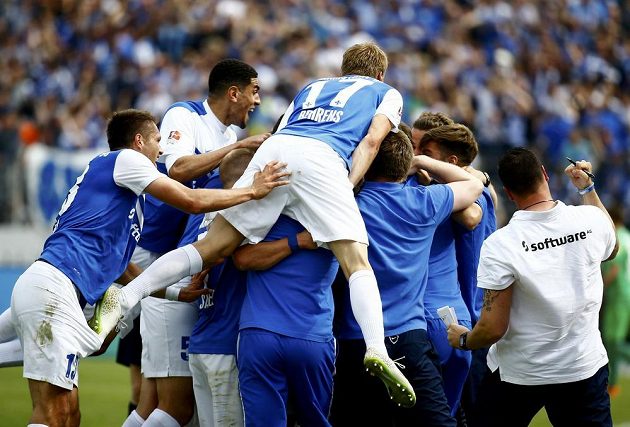 Tobias Kempe (není vidět) z Darmstadtu je zavalen svými spoluhráči poté, co dal postupový gól proti St. Pauli.
