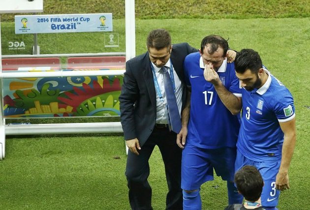 Zdrcený řecký fotbalista Theofanis Gekas (uprostřed) opouští stadión poté, co selhal v penaltovém rozstřelu.